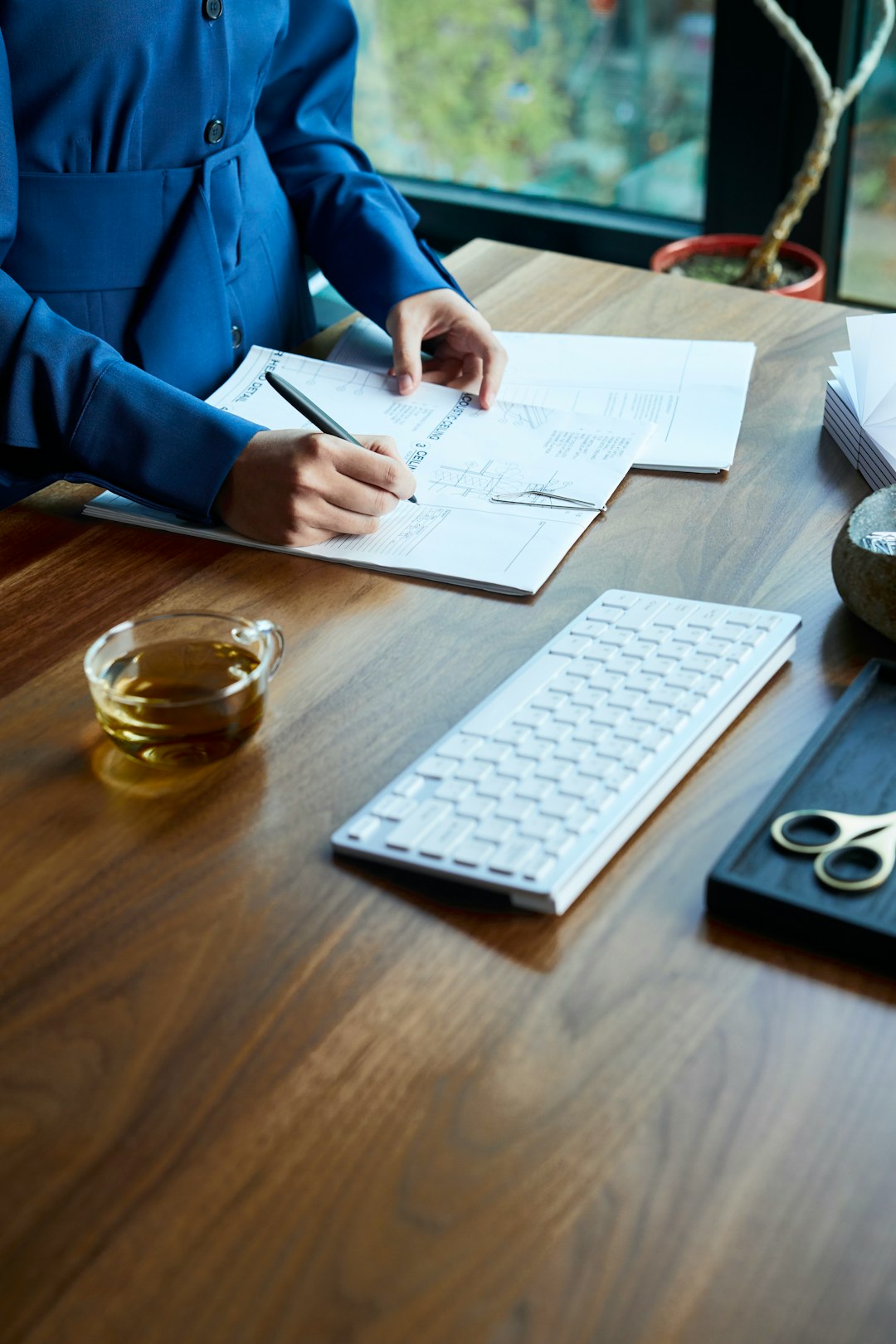 a-woman-sitting-at-a-desk-with-a-keyboard-and-papers-zxc-x67du